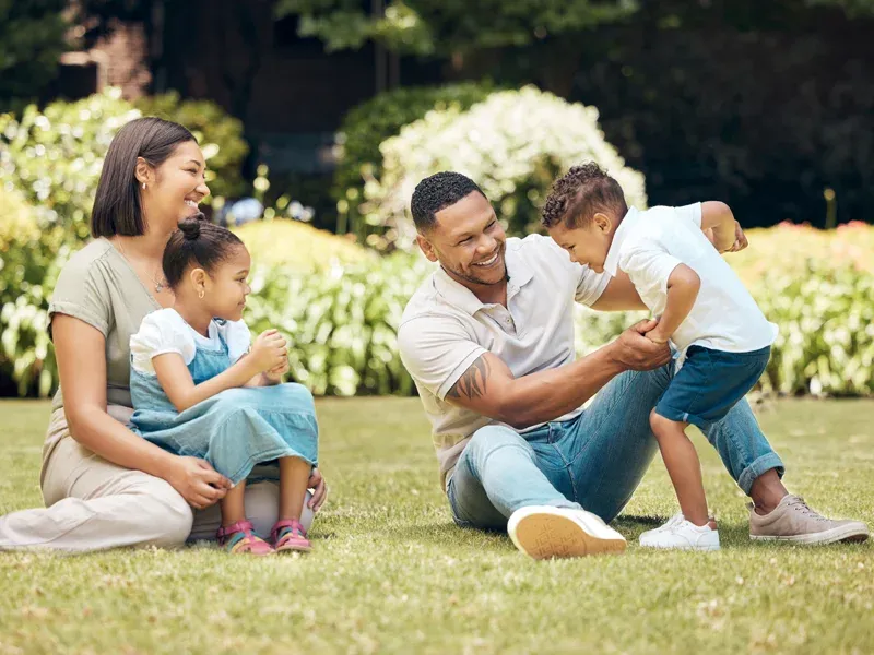 parents playing outside in front yard with kids