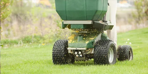 technician fertilizing lawn
